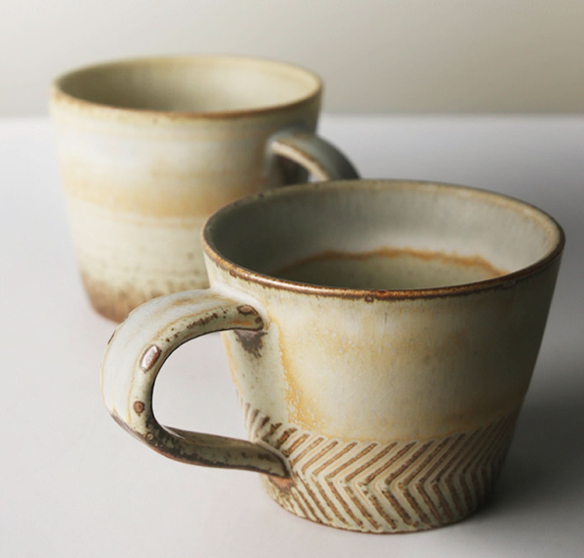 Japanese pottery mug with carved stoneware detail, natural earth tones.